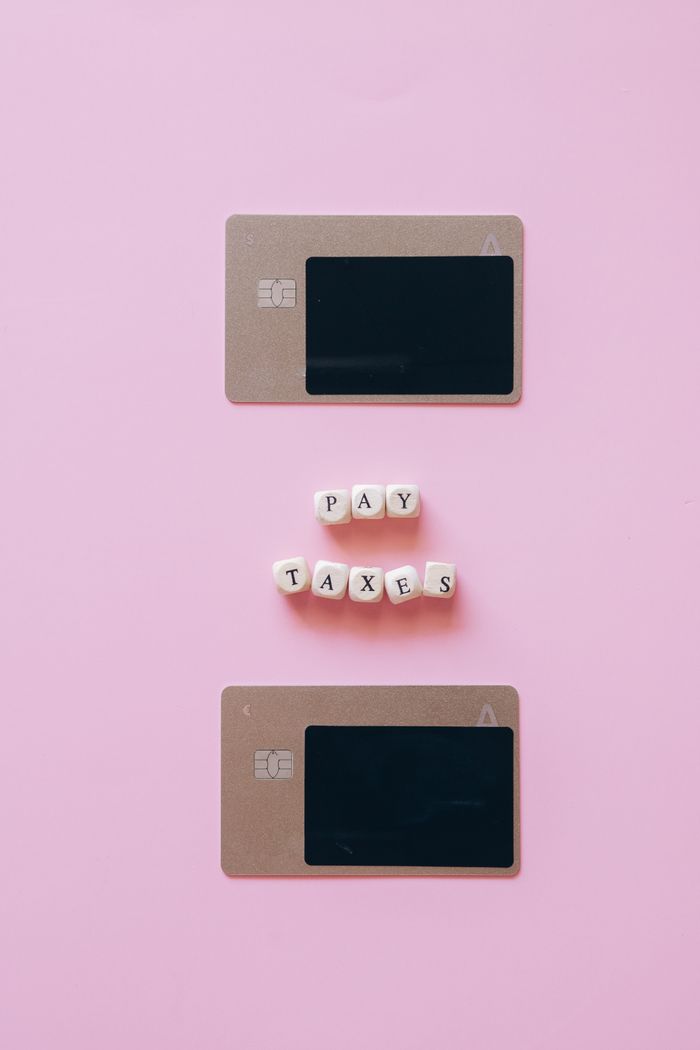 home-services-01 Artistic representation of tax payment using credit cards on a pink background.